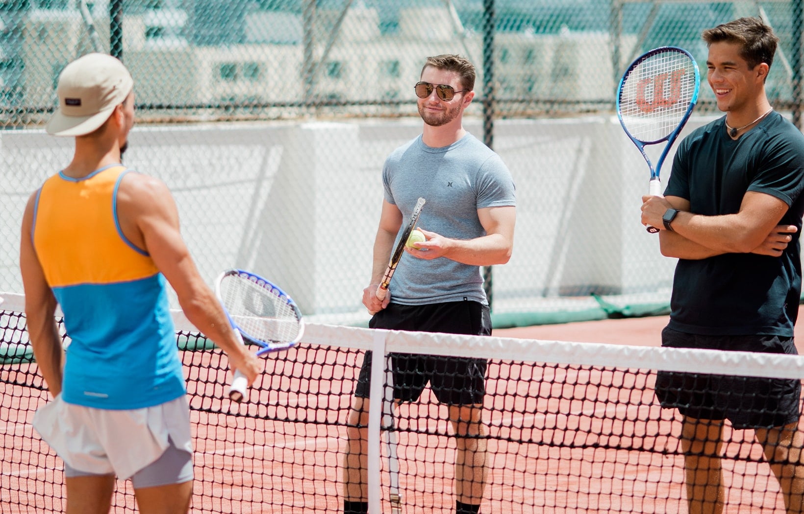 Guys on Tennis court standing near net