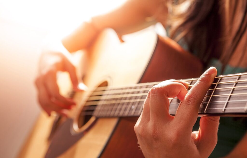 Close up of female hands playing acoustic guitar