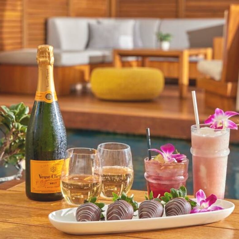 Chocolate covered strawberries, bottle of champagne and pink cocktails