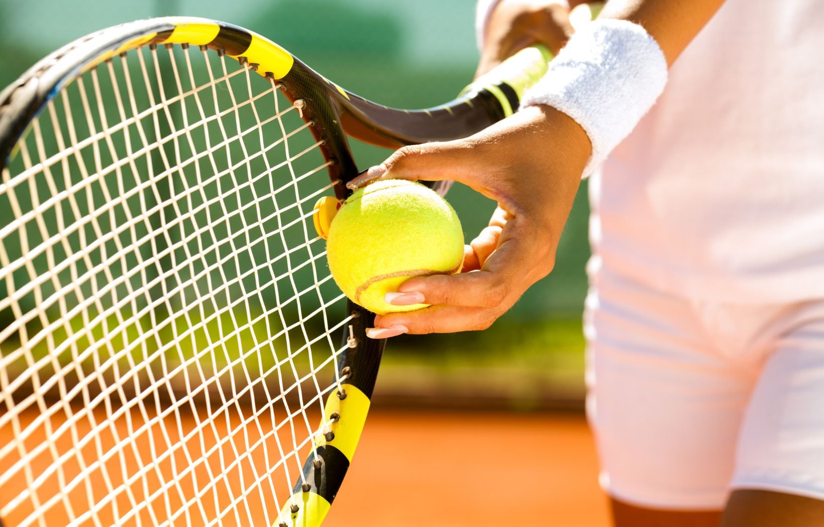 Close up of tennis racket and ball in hand